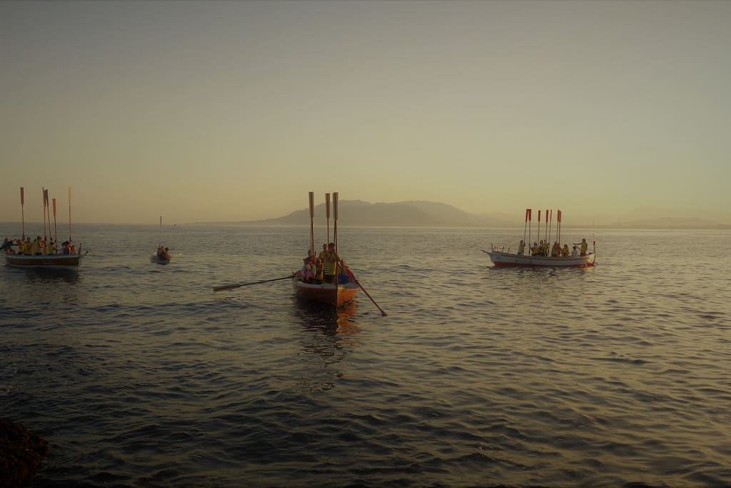 Los remeros de las barcas de jábega saludan el ocaso en el solsticio de verano.