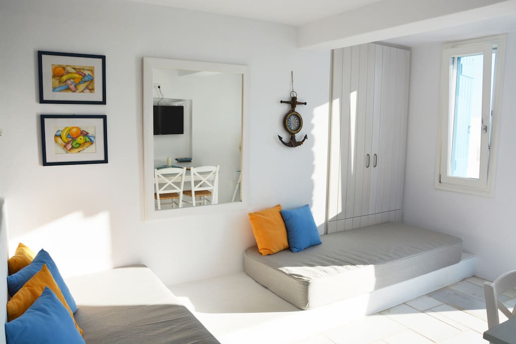 Living room with 2 sofa-single beds and dining table.