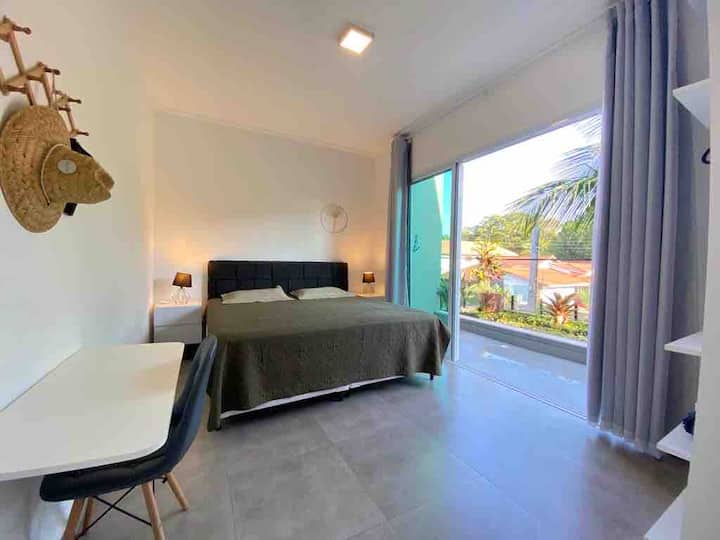 غرفة أكبر في الجناح الأول مع سرير بمقاس كبير، وشرفة مكيفة الهواء، وشرفة كبيرة تطل على المنزل مع أرجوحة شبكية للعمل 