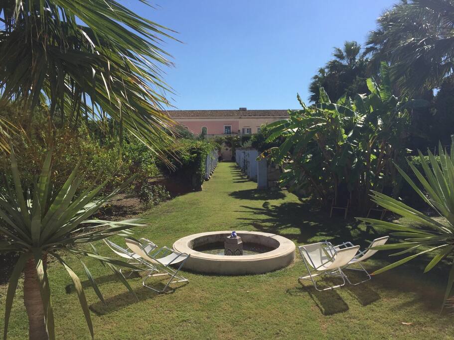 La villa bianca e rosa è al centro della proprietà di fronte ha il mare e dietro c'è il giardino che comprende anche la casa