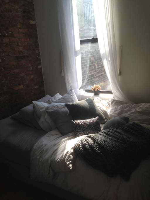 Other bedroom with exposed brick accent wall and west facing window