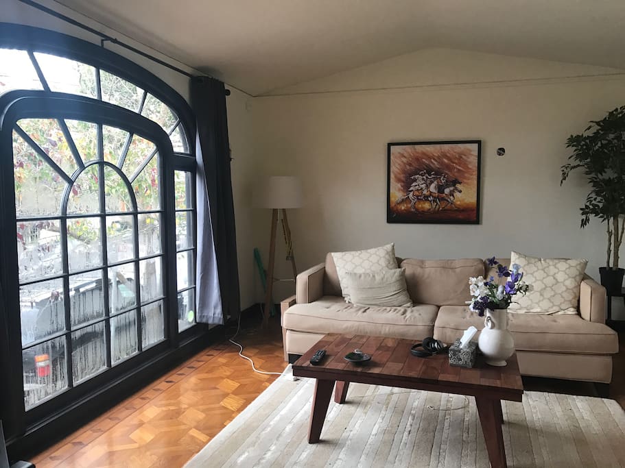 The living room has a spectacular arched window that lets lots of light in. (There is also a large TV behind the camera.)