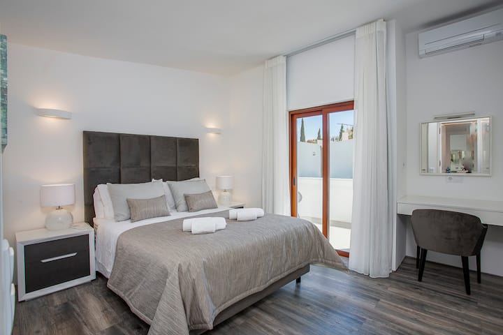 Dormitorio principal con cama tamaño king, armarios empotrados con espejo de cuerpo entero y tocador