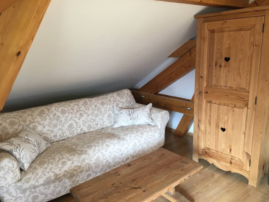 A comfortable sitting area and cupboard with shelves