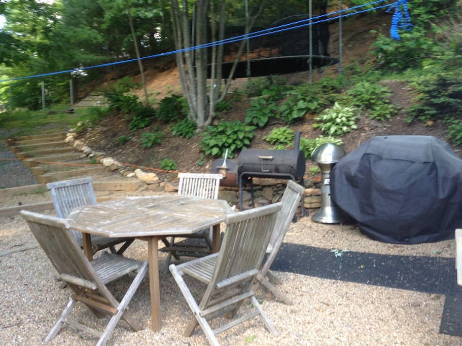Beautiful outdoor BBQ area, fire ring, and trampoline