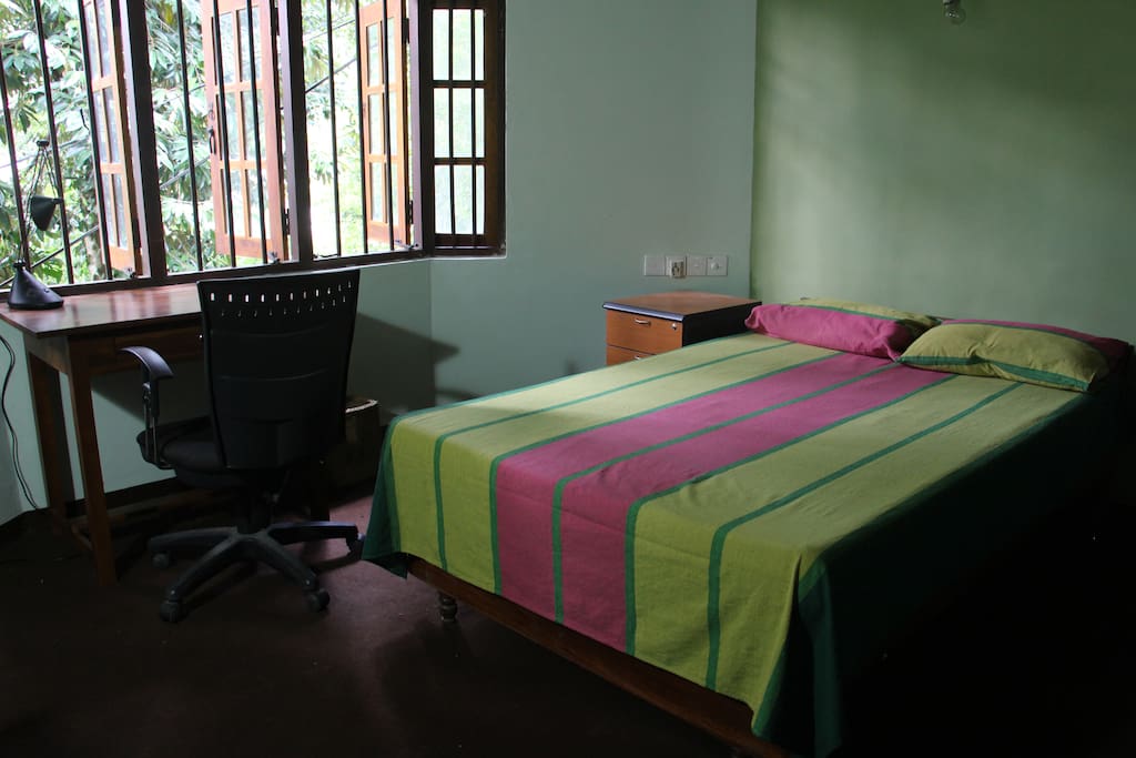 Bedroom - Mosquito net, writing table and racks are provided.