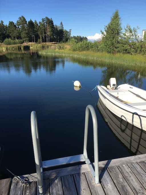Båt med åror att låna ligger förtöjd vid tomtens brygga