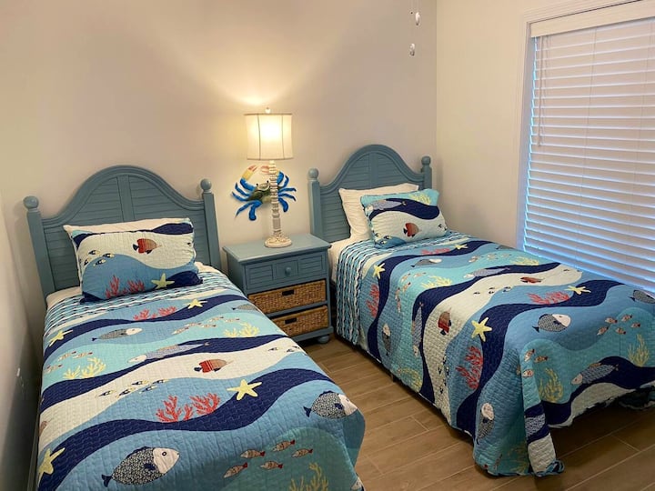 Schlafzimmer mit 2 Einzelbetten, Kommode. Das Badezimmer befindet sich direkt gegenüber dem Flur.