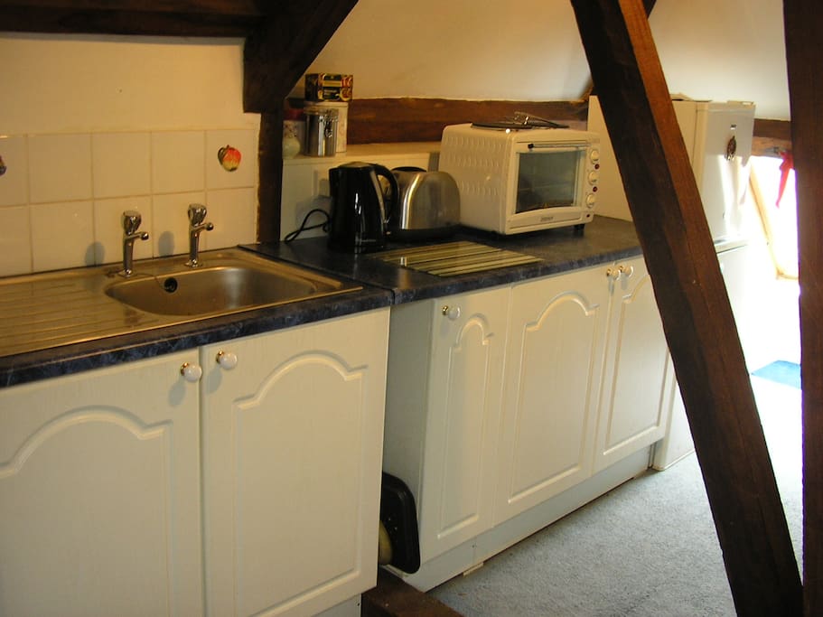 Kitchen area in sitting room. Table top cooker. fridge, microwave, freezer, toaster, kettle, slow cooker.