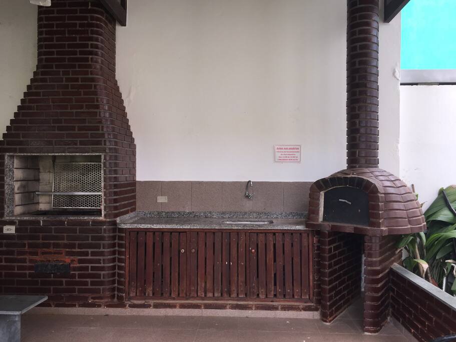 Churrasqueira e forno de pizza, ao lado do jardim.