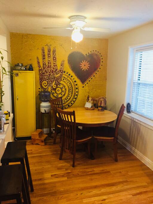 Dining area with table for four, leaf available, and two bar stools.