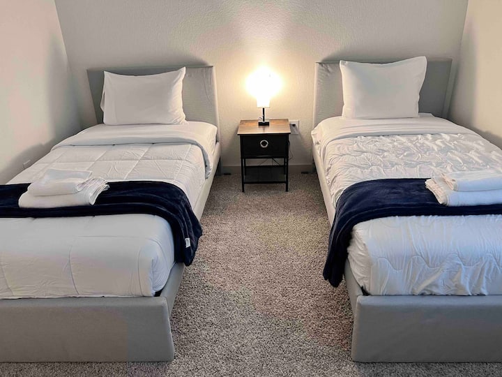 Spavaća soba 4 s 2 kreveta za jednu osobu i 1 noćnim ormarićem 