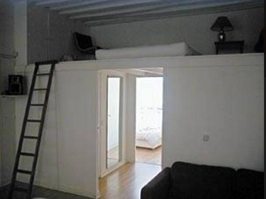The mezzanine is accessible by ladder. There is a blue curtain separating it from the living room for privacy. (see other photo)