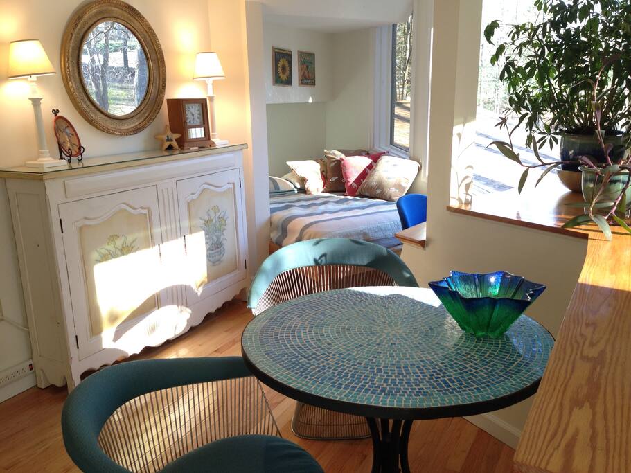 First floor: nook with full-size bed, dining area, bathroom on this level. Cabinet has kitchen essentials and room for guest items. Microwave and refrigerator.
