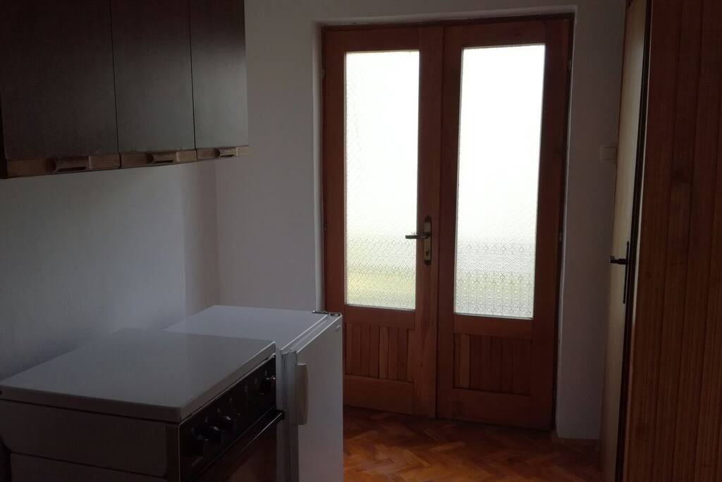 Hall with exit to balcony,fridge and gas stove