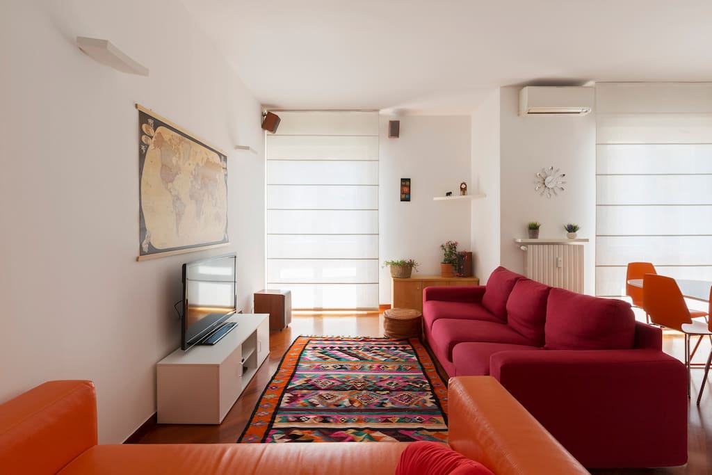 The living room zone: sofa bed x2, AC, TV & the dining table