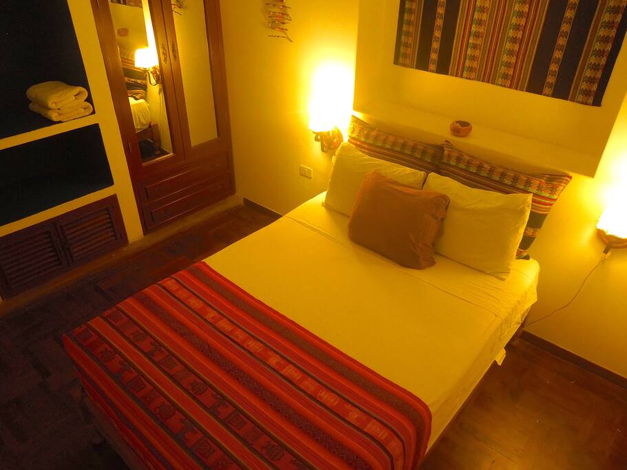 Habitación con cama matrimonial y armario amplio con espejos