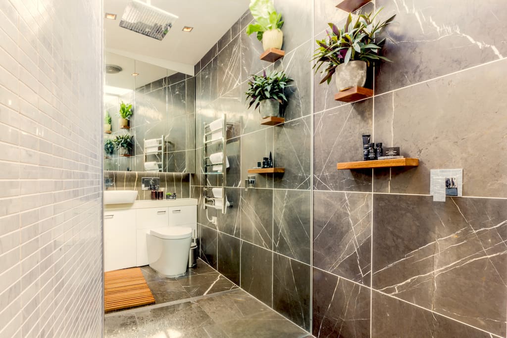 Ensuite Bathroom - clean & modern with large shower rain head.
This bathroom is light filled from the skylight above, the walls are mirrored & grey Marble.