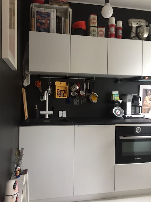Kitchenette with cooker, oven, microvawe, coffee maker and set of dishes.