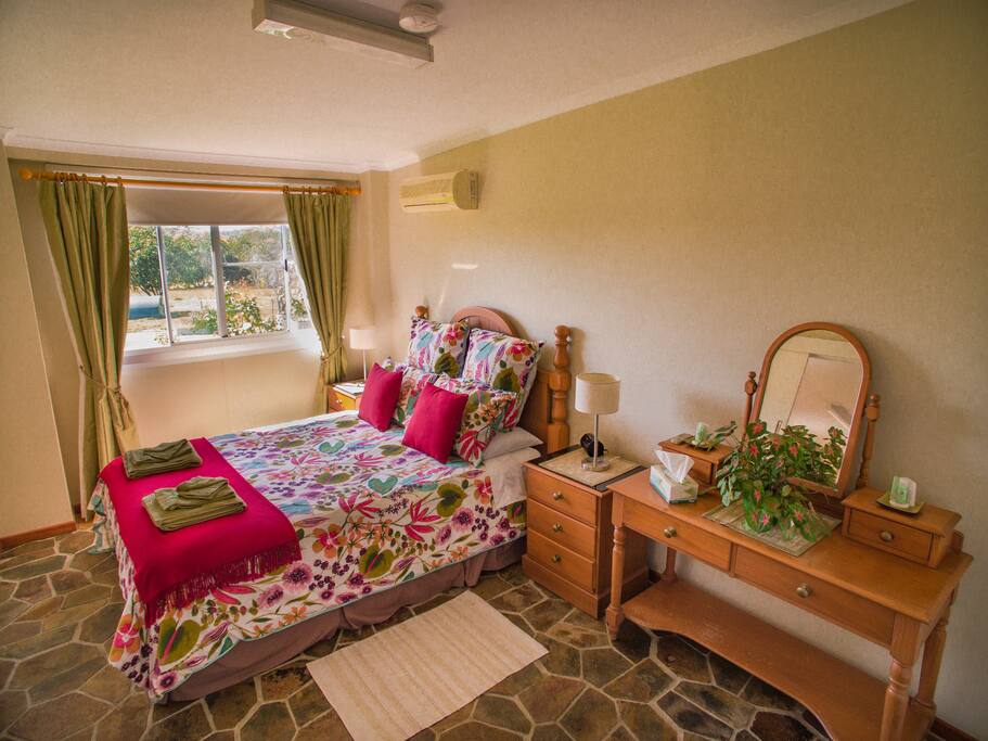 The bedroom is spacious with country views.