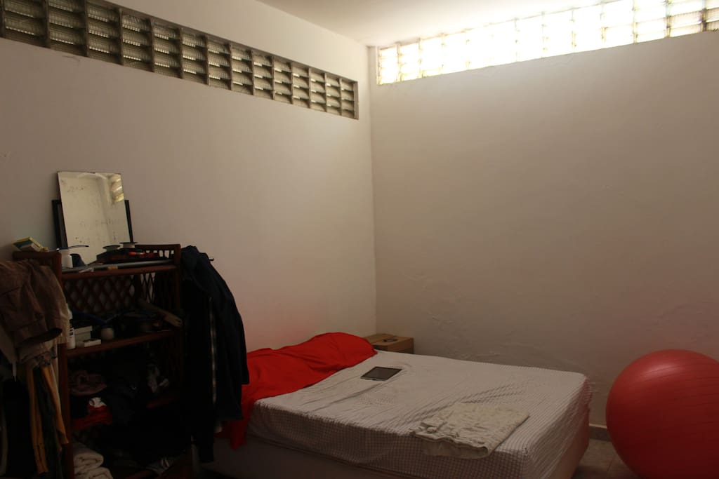 Janelas altas em cômodo semi enterrado garantem ventilação, iluminação e uma temperatura mais amena.