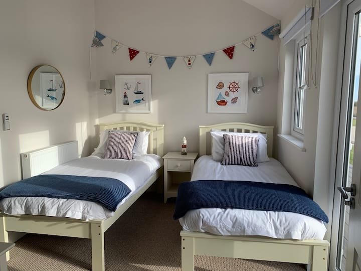 Habitación doble con camas individuales de tamaño completo y acceso al baño con bañera y ducha.