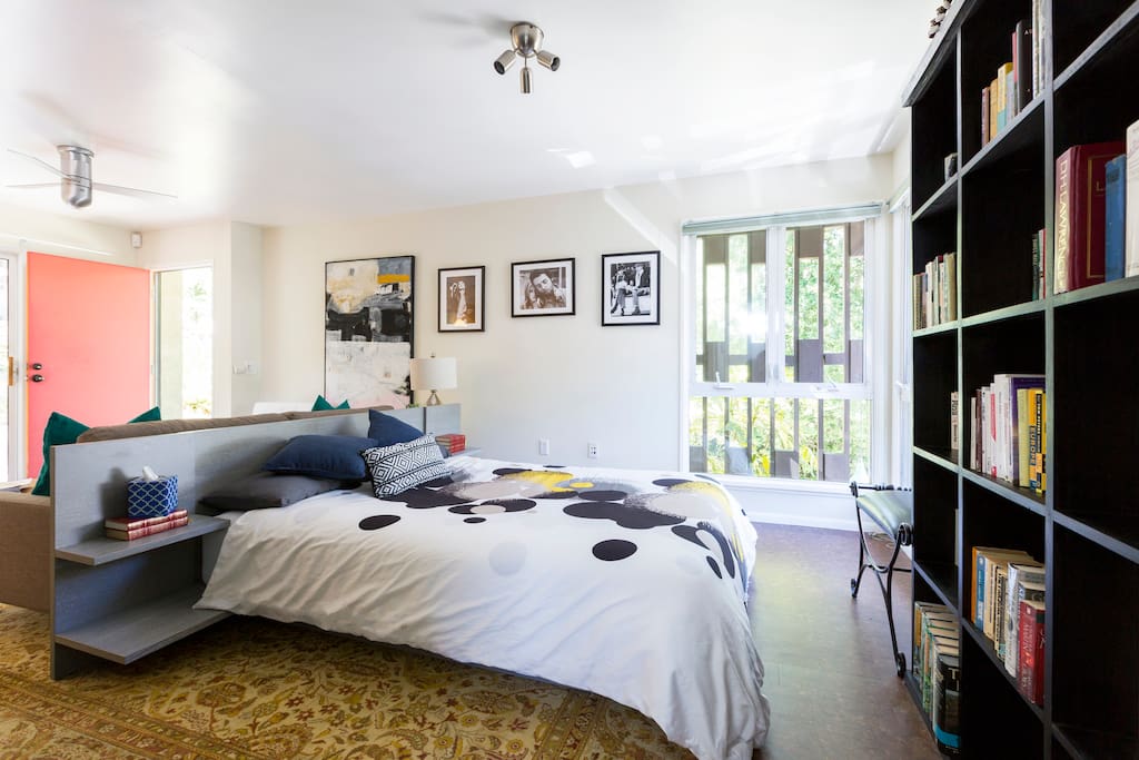 The bed & bookcase towards the back section of the studio