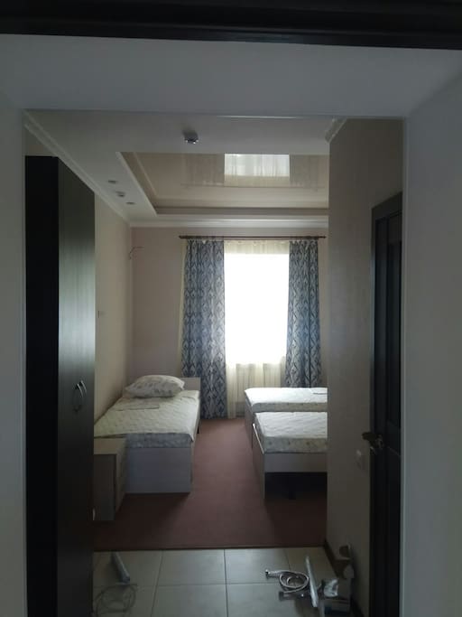 Room with 3 beds, shower, closet, drawers and toilet.
Комната с 3 кроватями, душевой кабиной, шкафом, ящиками и туалетом.