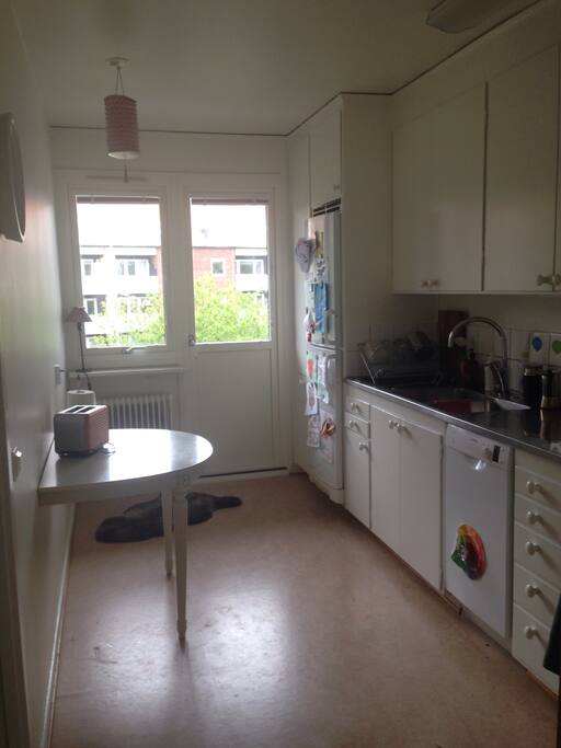 Kök med diskmaskin och balkong.