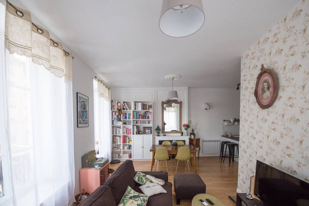 Séjour très lumineux avec trois fenêtres, volets intérieurs et rideaux voilage. Canapé lit deux places dépliant, table à manger, TV, internet, platine vinyles...