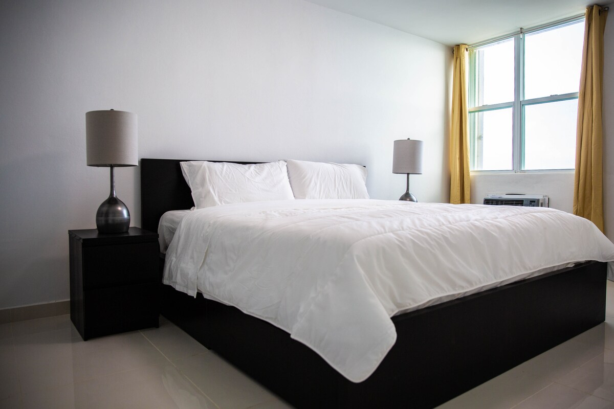 Rust uit op een supercomfortabel kingsize bed in de hoofdslaapkamer met een inloopkast en uitzicht op de oceaan. 