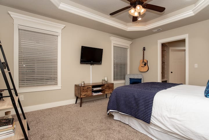 Master bedroom with HD TV completely ready for you to chill or perhaps compose the next great country song with the acoustic guitar.