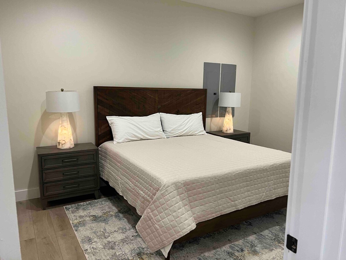 Spálňa pre hostí na nižšej úrovni s manželskou posteľou King a namontovanou televíziou (fotka 1 z 2)