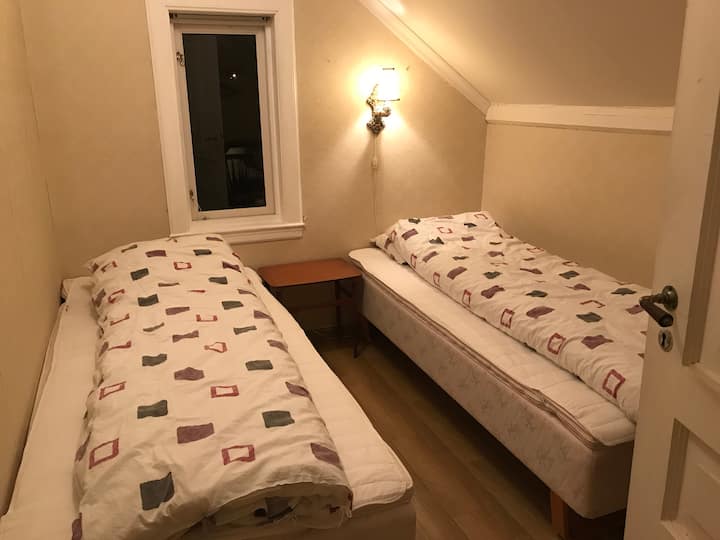 Chambre 4. Deux lits simples. Il y a une commode dans la chambre.
