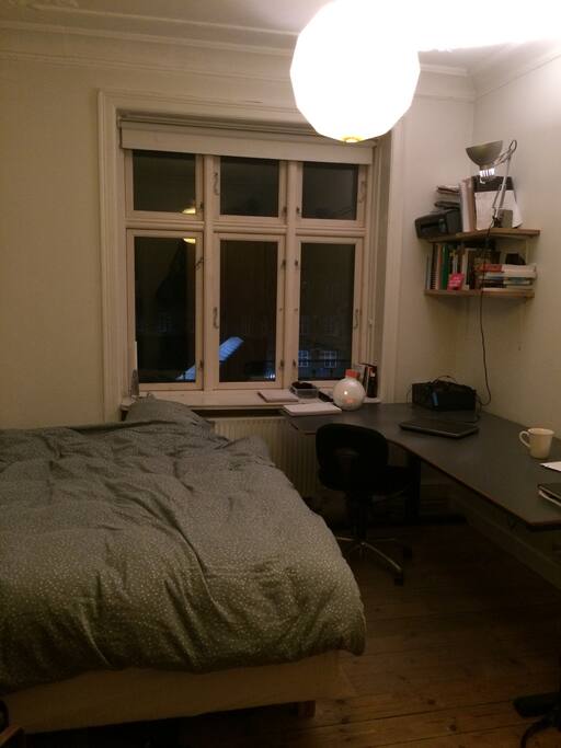 One of the bedrooms with a large, height-adjustable desk