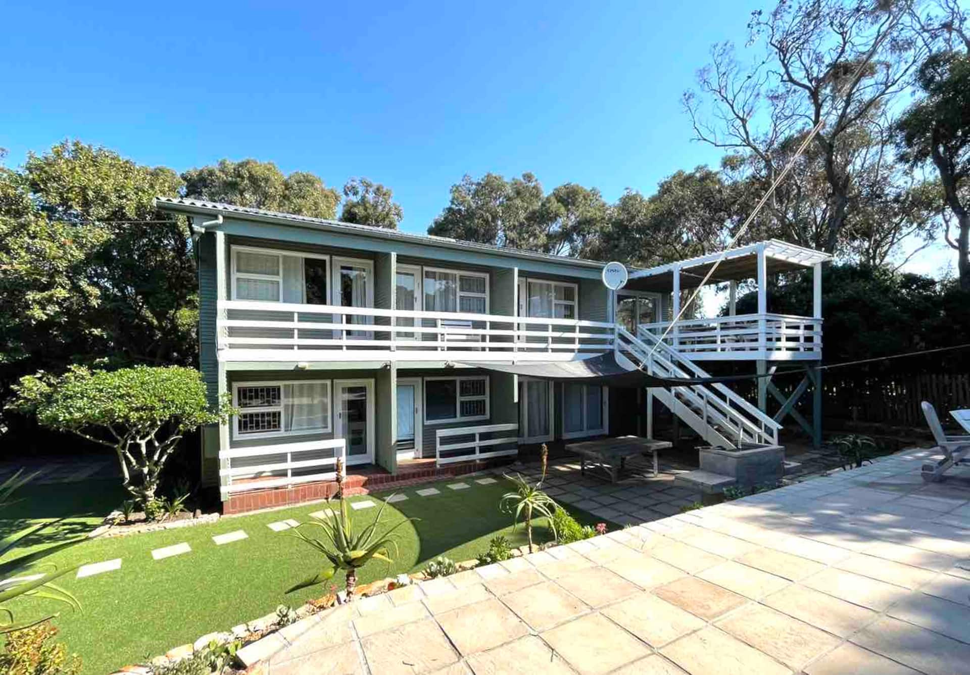 The Flamingo Beach House exterior nestled among trees in Kommetjie
