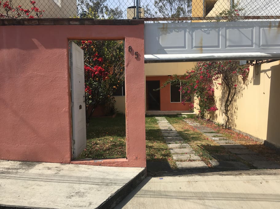 Entrada con cochera y jardín