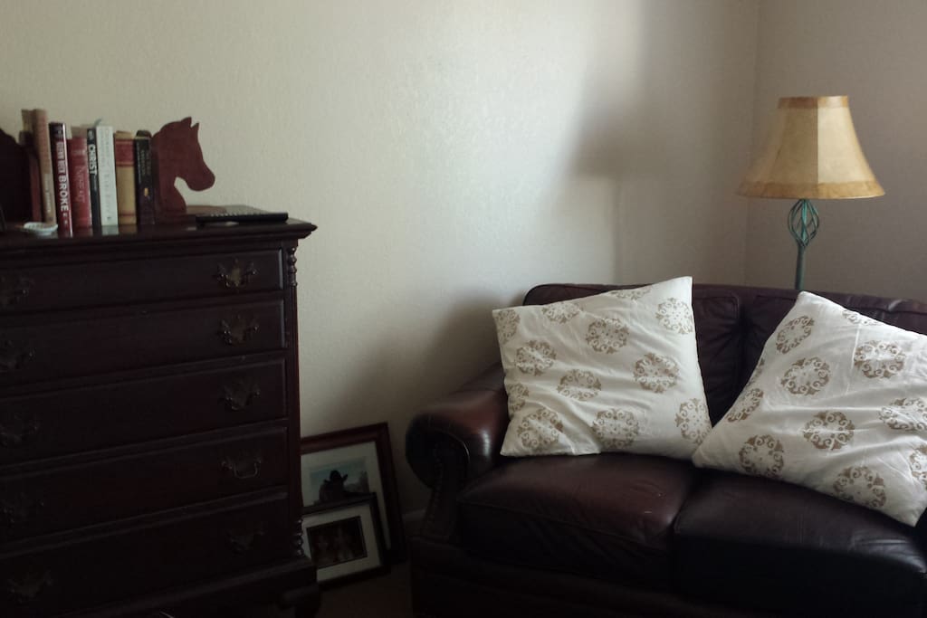 Adjacent TV/living/reading room with leather chair and love seat.