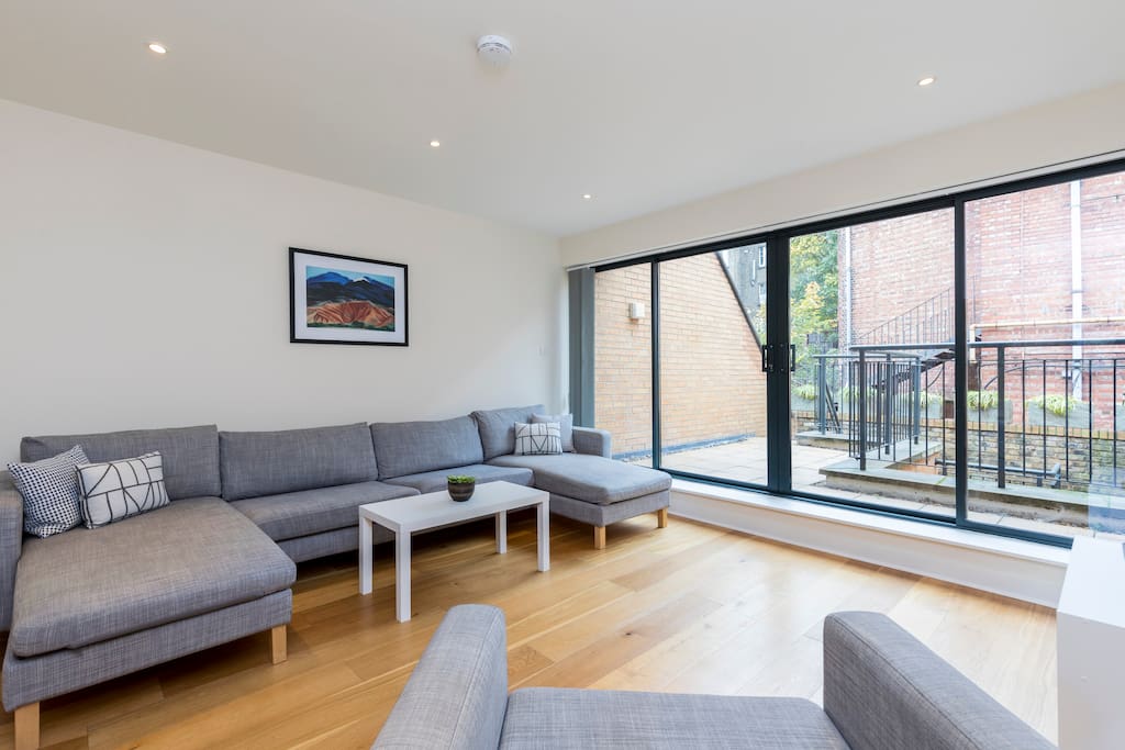 The stylish living area has huge glass doors to let in lots of natural light and access to a terrace.