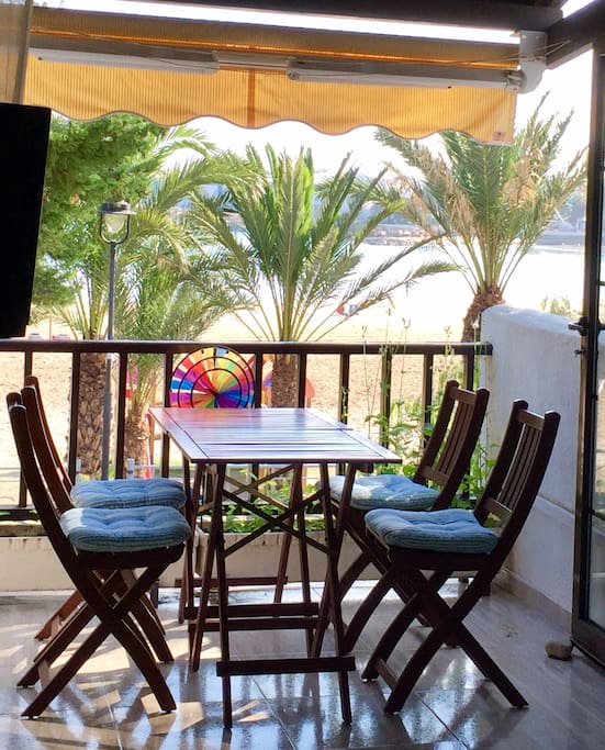 Mesa y sillas terraza frente a la playa con vistas al mar