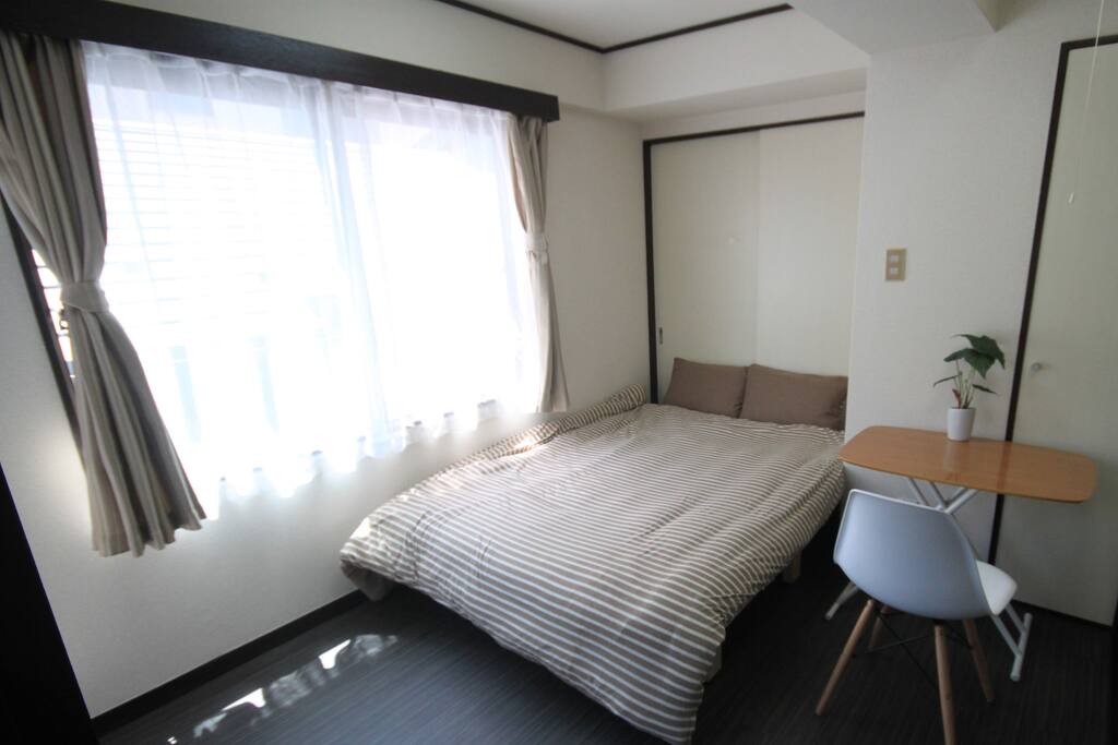 Bed Room 1 has a table, a chair, an air conditioning and is blight with two windows.