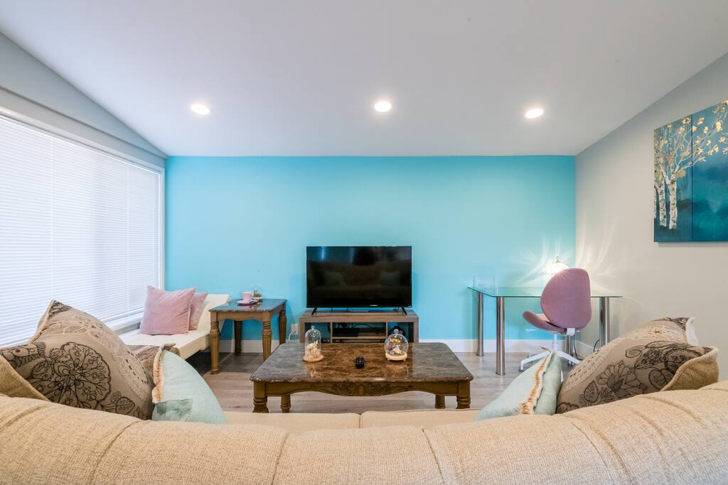 The living room has a smart TV (with Netflix subscription), 5G Wifi (through the whole house), a set of working desk/chair, and a lounge bed.