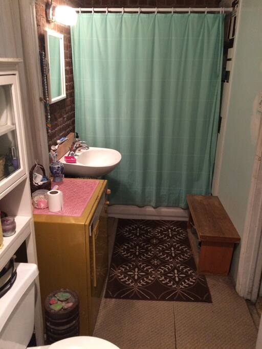 Large bathroom with gym bench and exposed brick walls