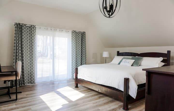 La chambre principale avec lit King Size, salle de bain attenante et espace de travail