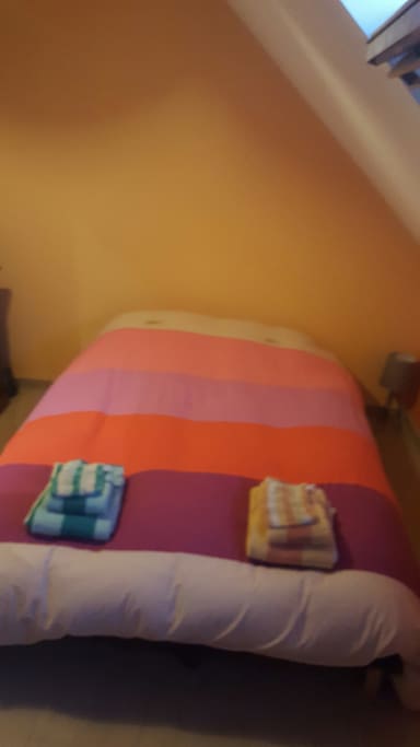 Le lit double avec les serviettes de toilette