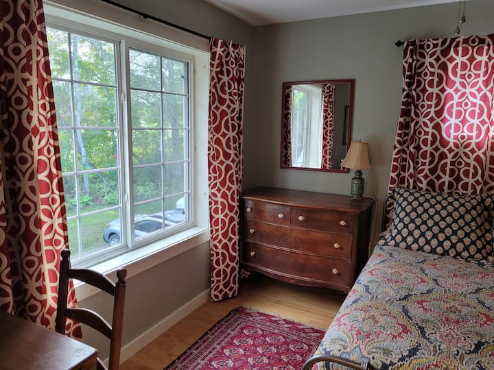 غرفة نوم خلفية بسرير كامل وإطلالة جميلة على الغابة