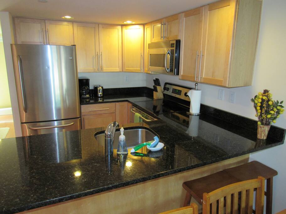 Kitchen with coffee pot, toaster, and stainless steel appliances.