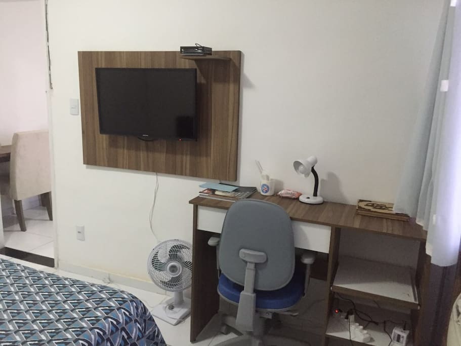 Área de trabalho e TV a cabo no quarto