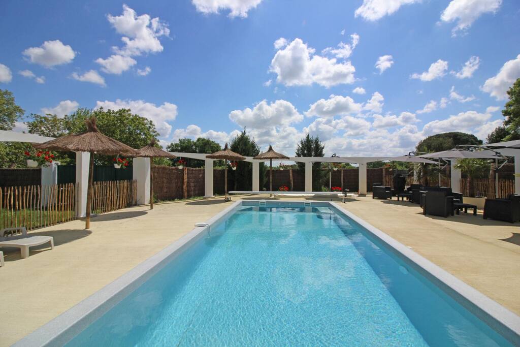 piscine eau salée à partager, avec transats et salon de jardin en été et parasols