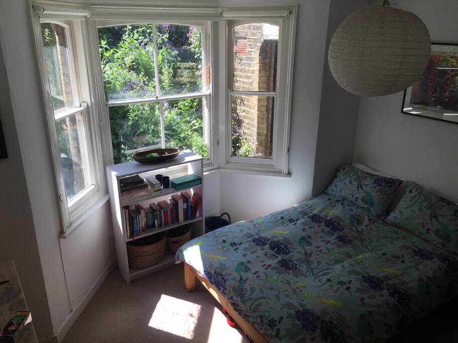 The room, there is a large cupboard on the wall opposite the windows.